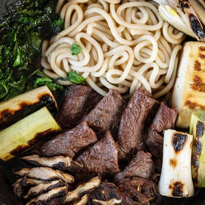 Sukiyaki s plátky grilovaného Wagyu s houbami shiitake, tofu, nudlemi a grilovanou zeleninou